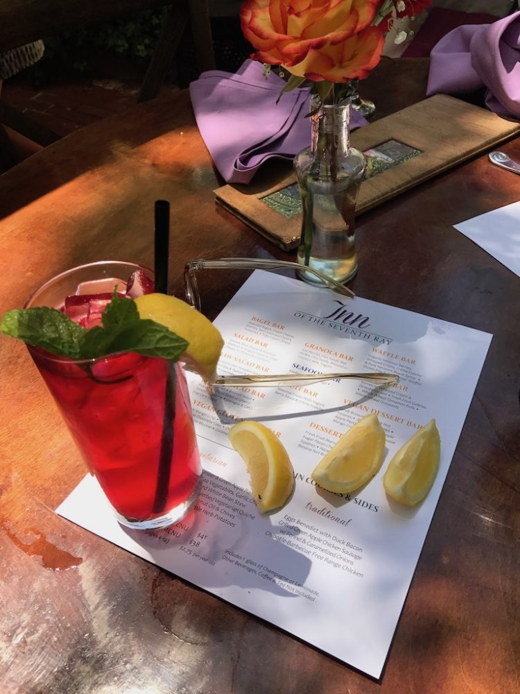 A drink on a table next to a menu.