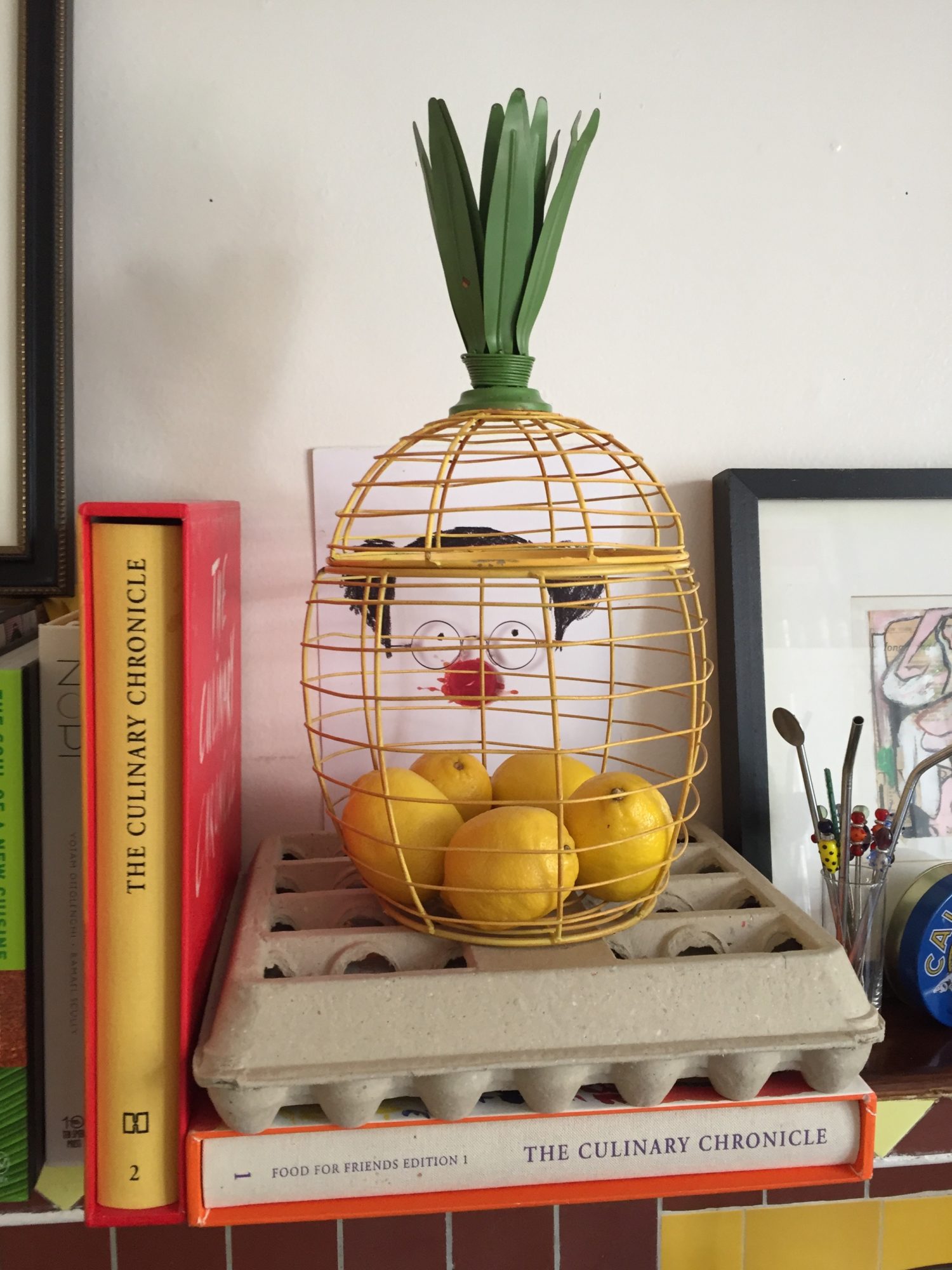 A pineapple in a cage on a shelf.