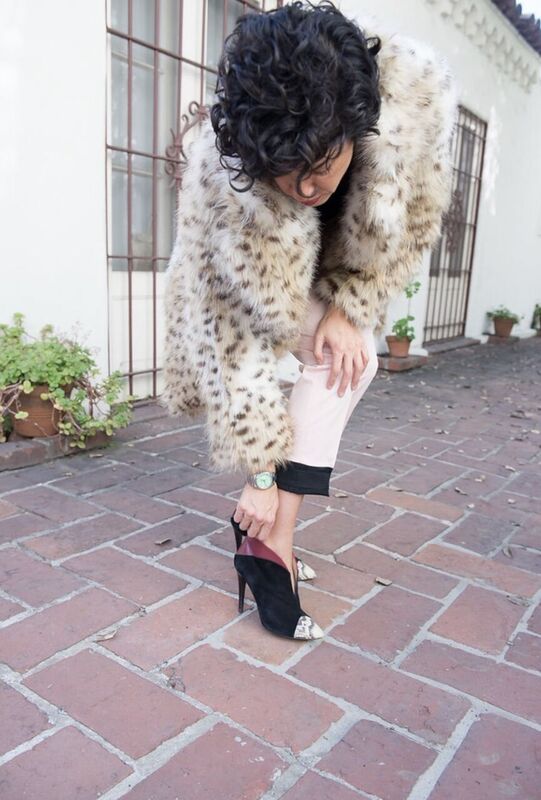 A woman wearing a leopard fur coat and heels.