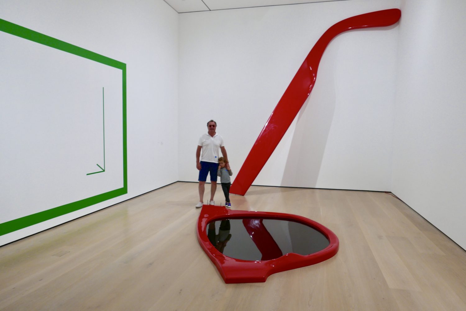 A man standing in front of a red and green sculpture at The Hammer Museum.