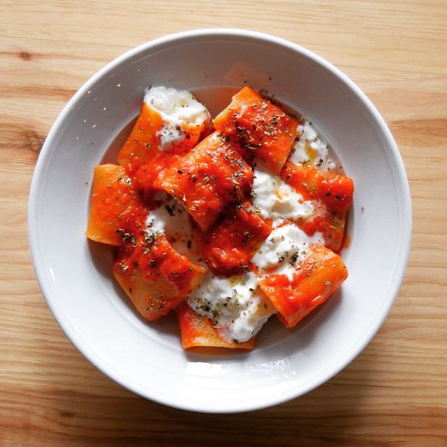 A delicious bowl of Colapasta with tomatoes and feta cheese.