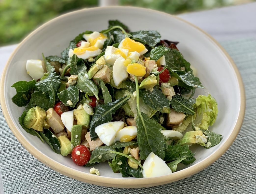 A bowl of kale salad with a hard boiled egg on top at The Rosewood Miramar.